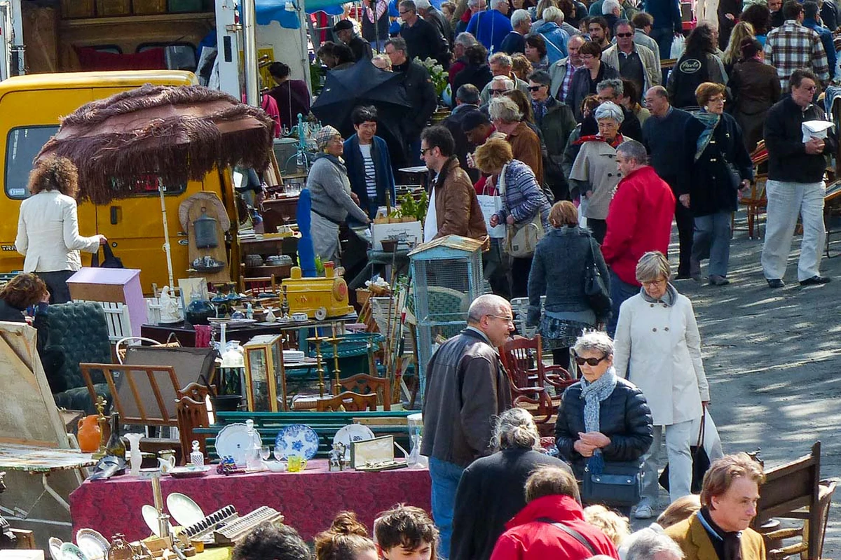 Des vendeurs enthousiastes proposent des vêtements vintage, des livres anciens et des meubles d'époque lors de la grande braderie.