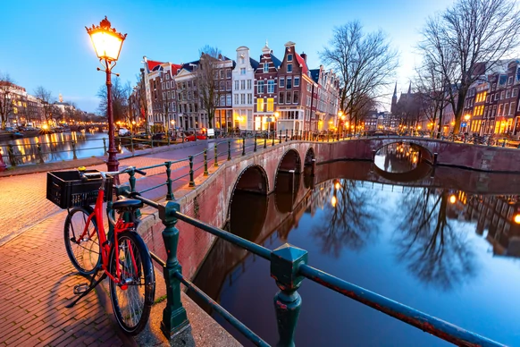 Amsterdam, offrant une expérience confortable pour explorer la ville, ses ponts emblématiques et ses bateaux naviguant sur le fleuve.